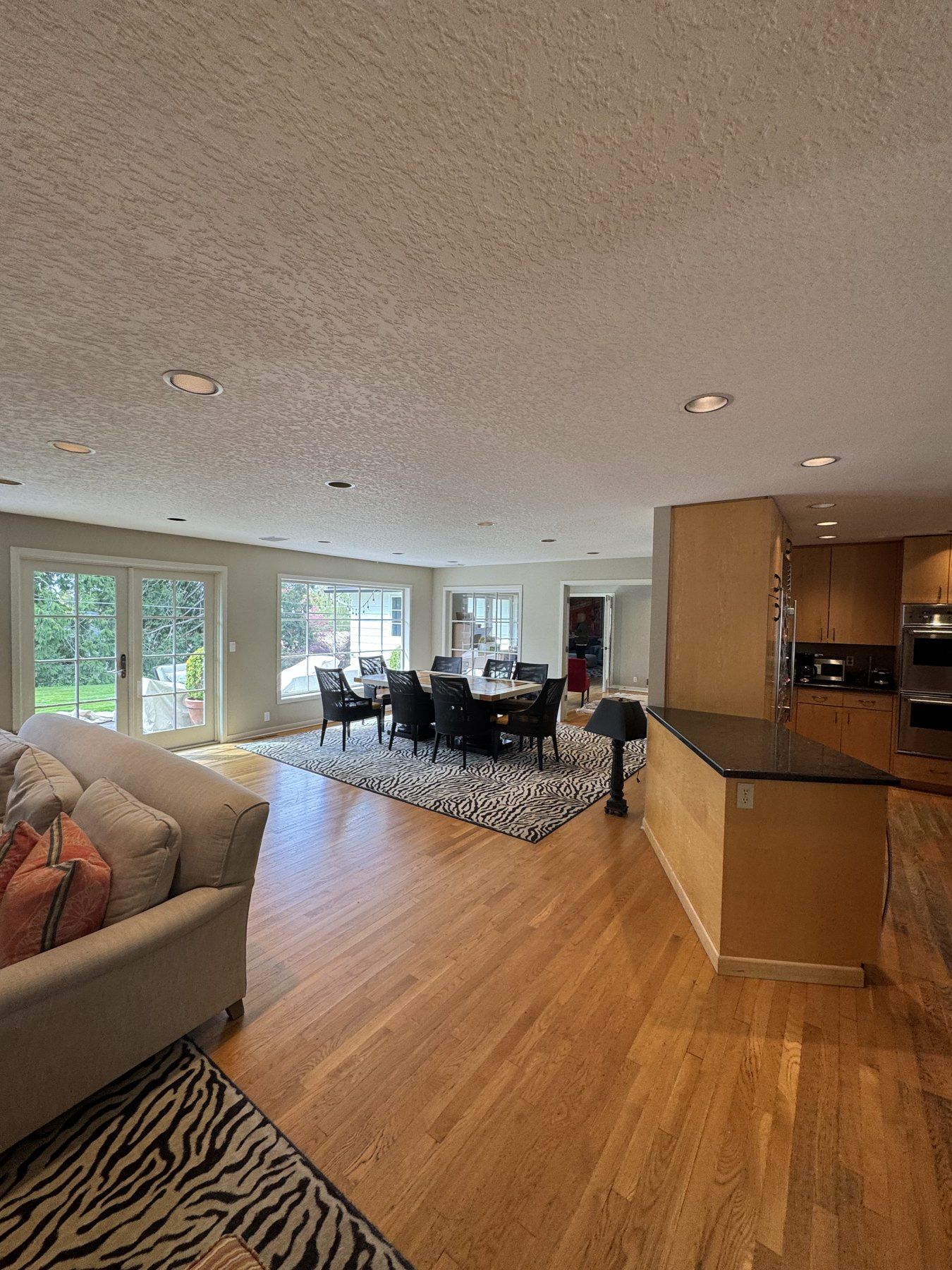 Before: the original kitchen with honey-toned cabinets and a dark peninsula separating it from the living room