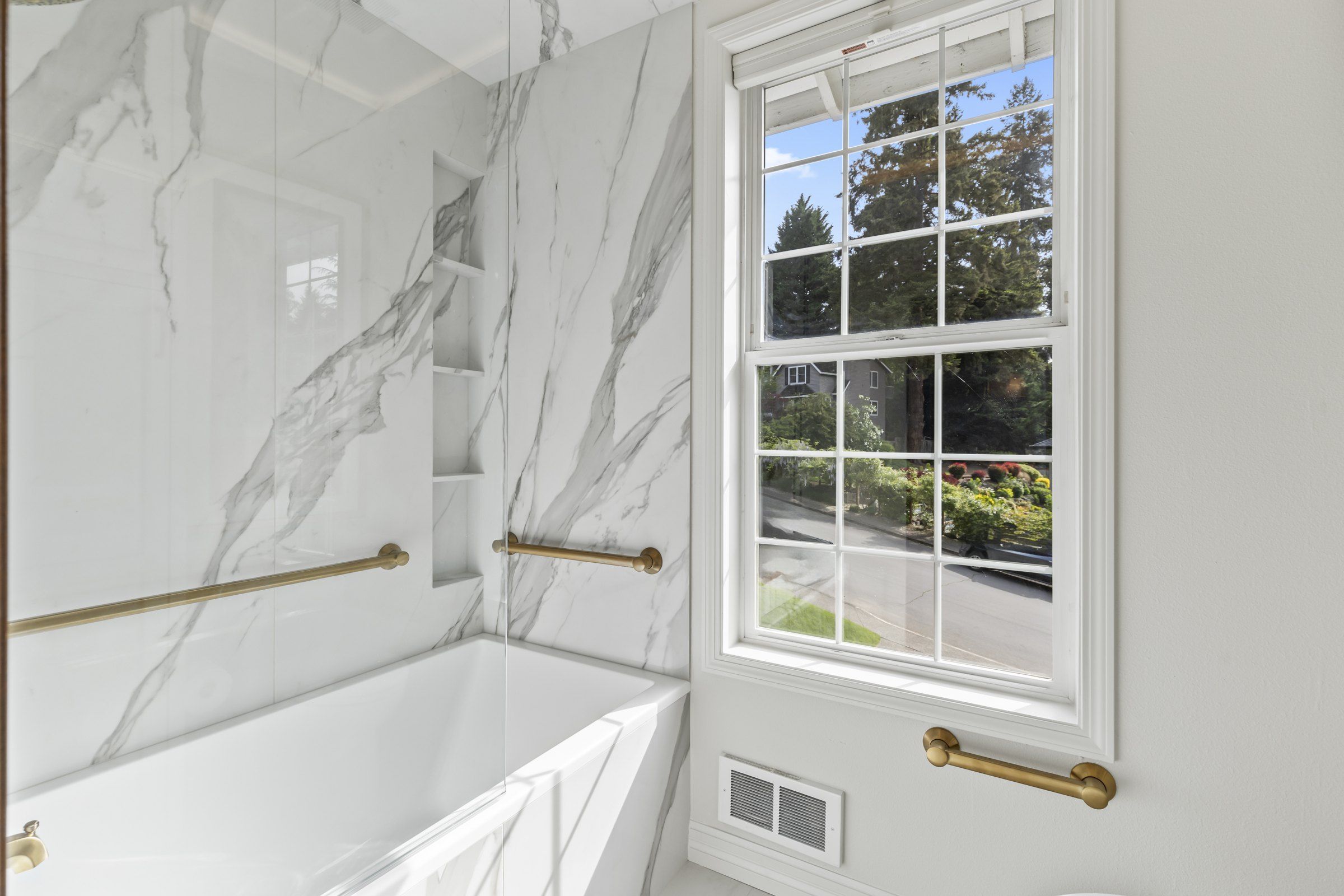 Soaking tub beside a window with a view of the trees