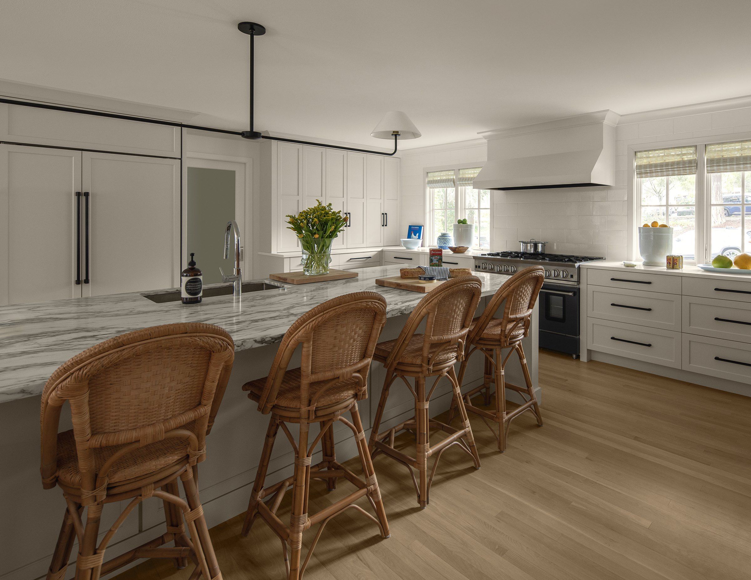 Island with rattan counter stools and an open view through to the dining and living areas