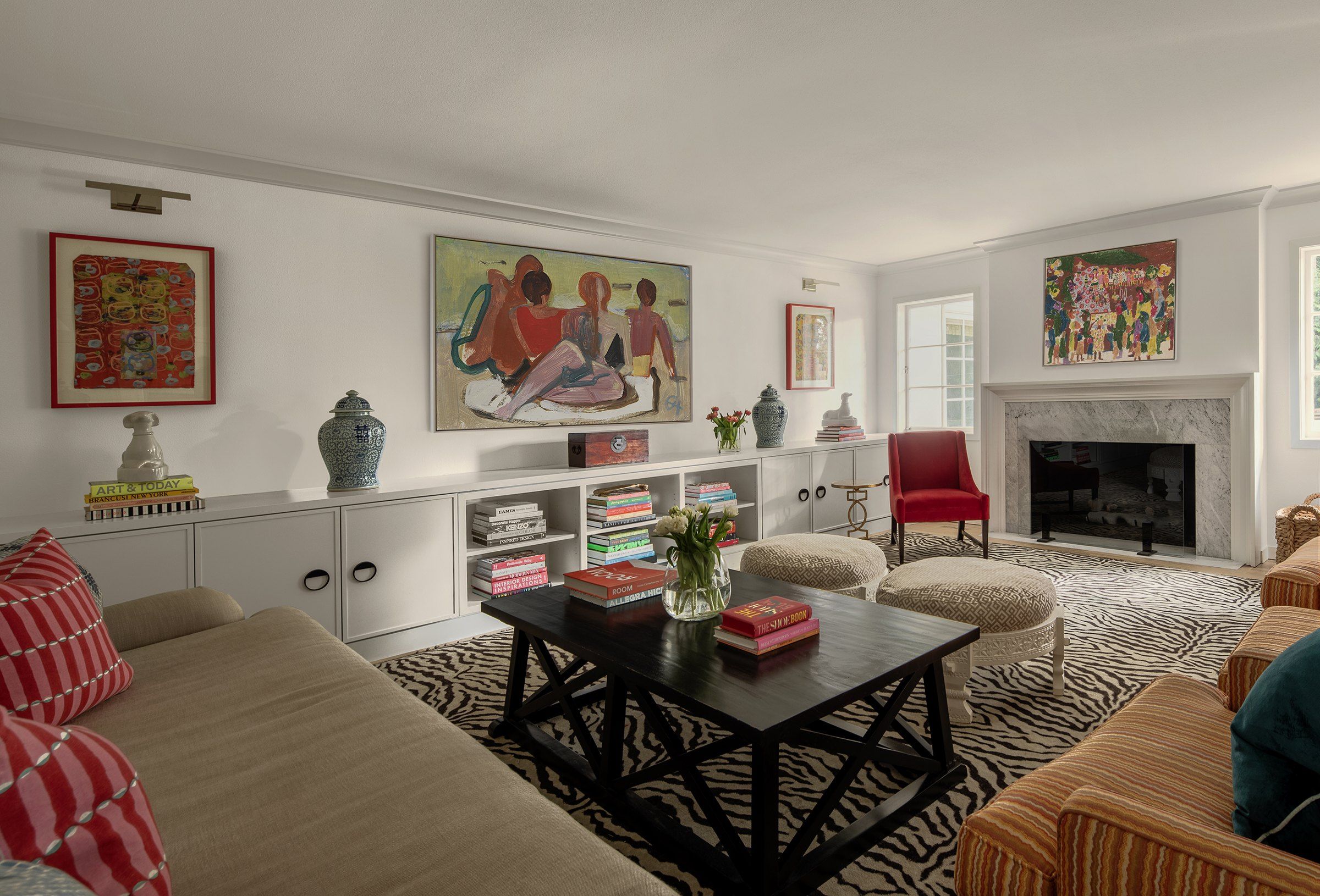 The living room that now opens to the kitchen, with a fireplace and built-in shelving