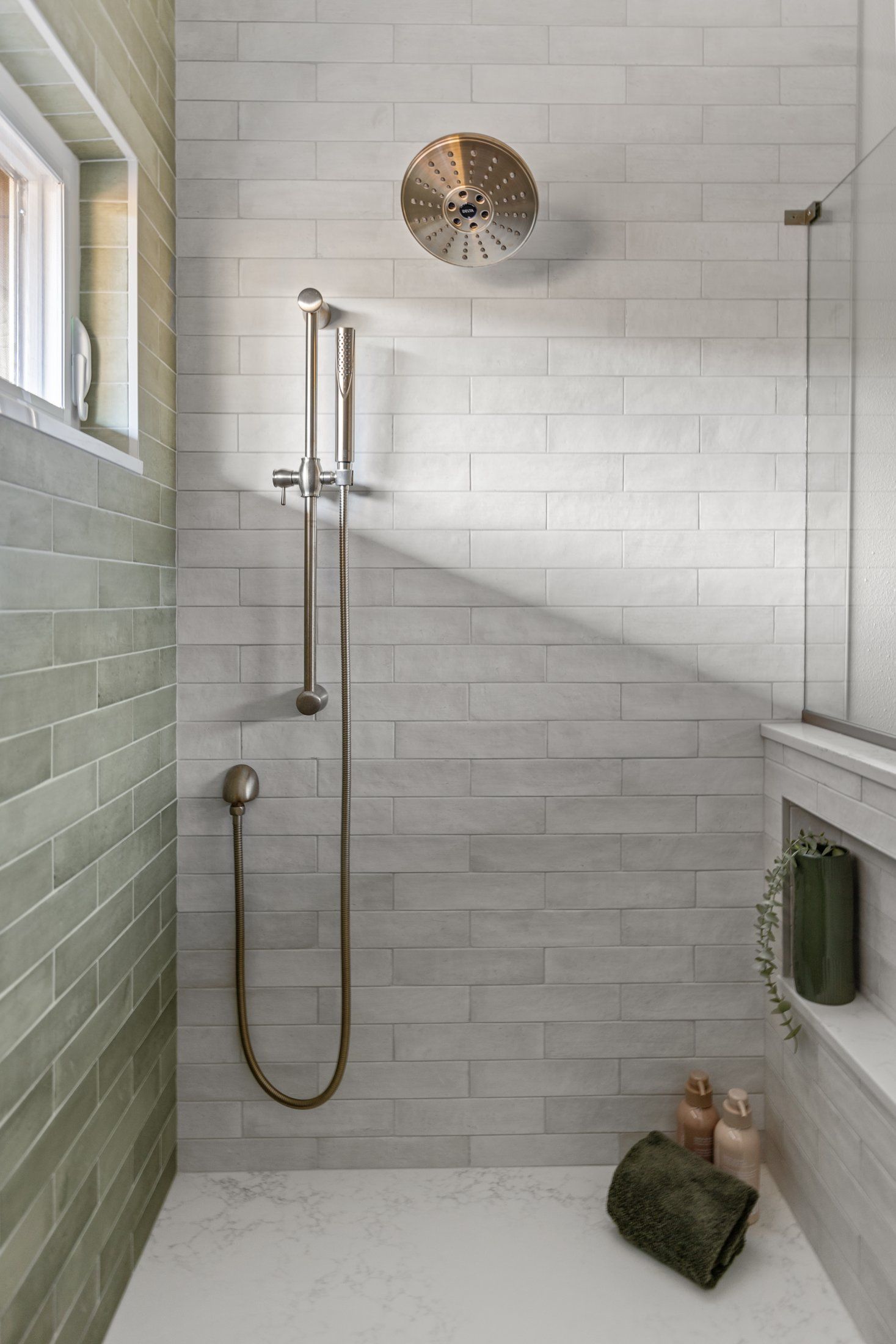 Curbless shower with a rain showerhead, handheld shower, bench and niche