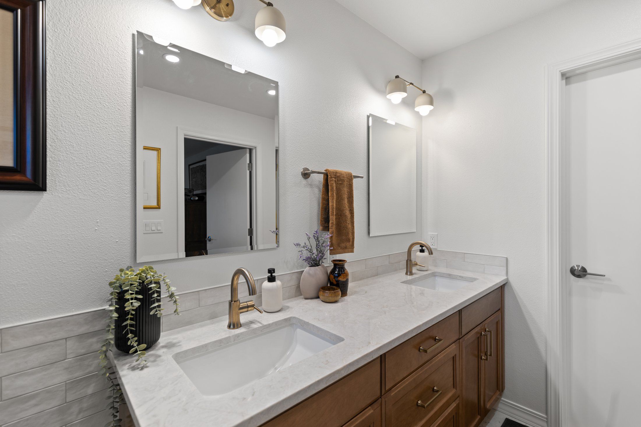 Angled view of the double vanity with brass hardware and fixtures
